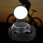 Circular bicycle rear view wrist mirror with dark strap, mirror cover open