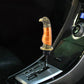 Black gear shift knob with gold eagle head and orange band, eagle beak topper