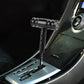 Universal car gear shift knob with T-shaped handle, black finish, mounted in center console