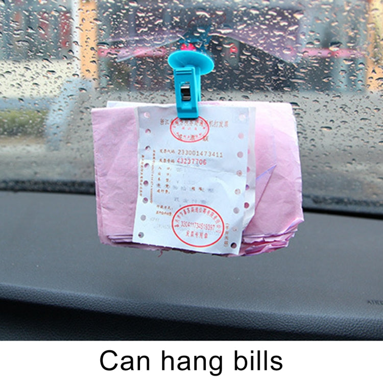 Blue suction cup clip holding bills on car dashboard