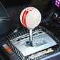 White resin gear shift knob with red stripe bands and 5-speed number markings