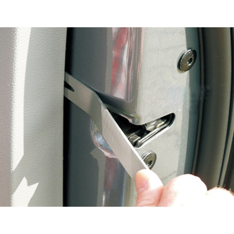 Metal wrecking bar inserted near a door hardware area for prying