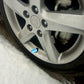 Blue hexagon tire valve stem cap on wheel, installed near the valve stem