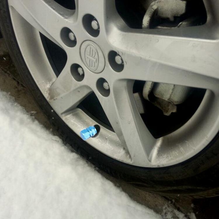 Blue hexagon tire valve stem cap on wheel, installed near the valve stem