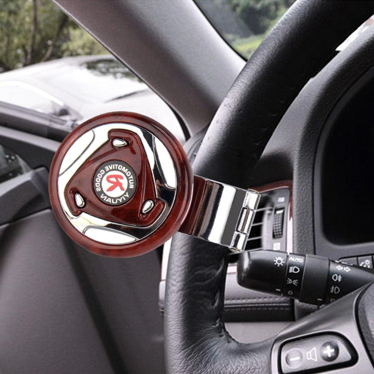 Red wheel spinner knob attached to car steering wheel with chrome mounting bracket