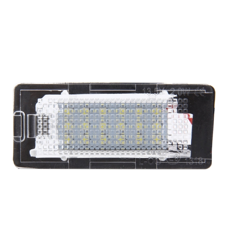 License plate light lens with embedded white LED chip array behind clear cover
