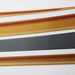 Close-up of gold metallic body strip sticker with fine mesh texture and dark underlayer