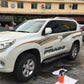Applied gold-and-black body strip decals on white SUV door and fender