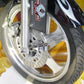 Motorcycle alarm warning lock attached to front wheel, black lock and metal cylinder