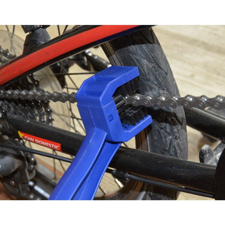 Blue chain cleaning brush with bristles scrubbing chain between wheel and frame