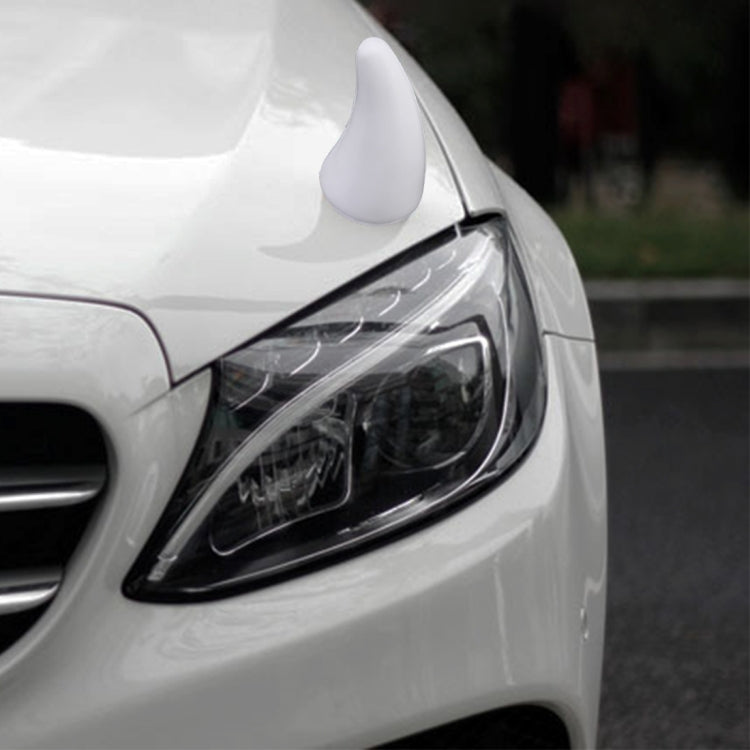 White decorative rubber car horn cap, mounted near the front headlight.