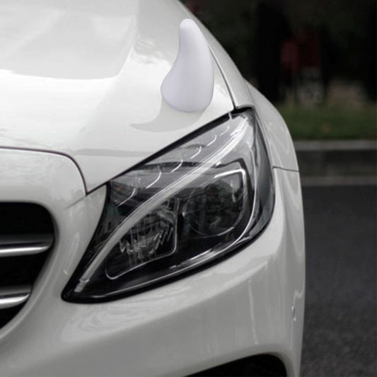 White decorative rubber car horn cap, mounted near the front headlight.