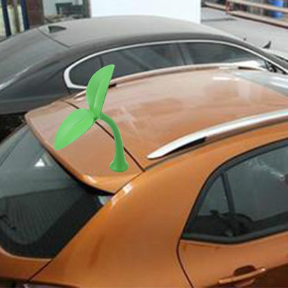Green decorative rubber grass topper on car hood near windshield and wiper