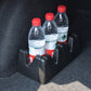 Black plastic vehicle bottle holder with three drink bottles and red caps