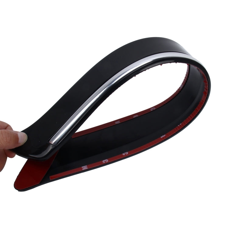 Black bumper guard strip with chrome-like trim, held by hand