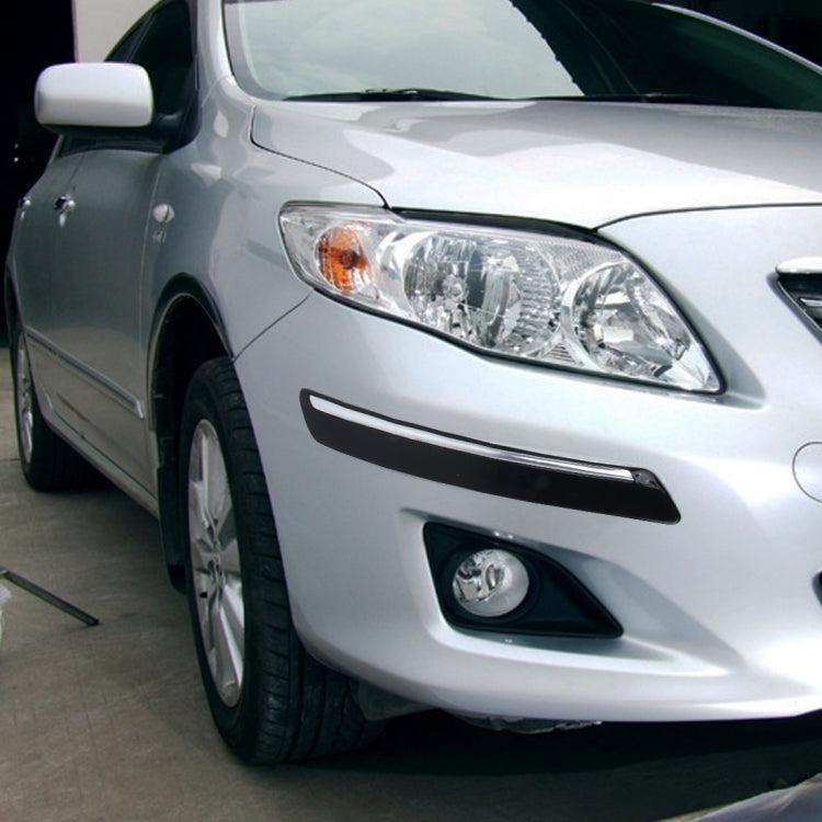 Black bumper guard strip on front bumper lip of a car
