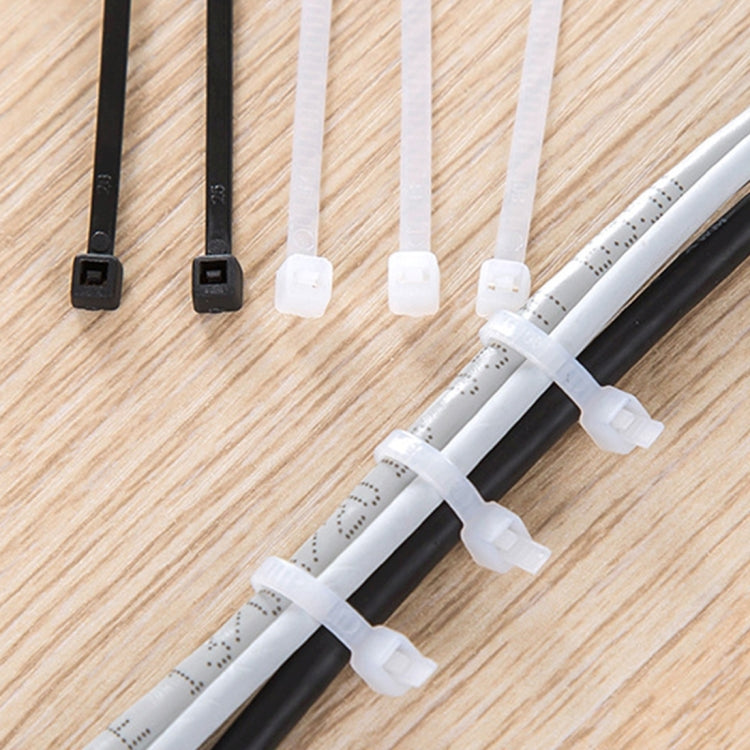 White nylon cable ties with locking heads, grouped on wood surface