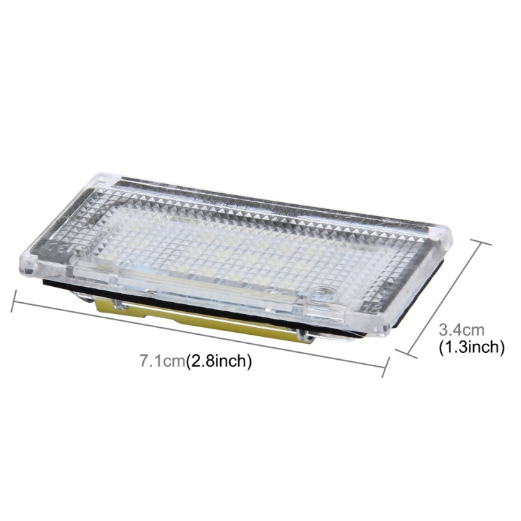 Rectangular license plate light with clear lens and yellow mounting base, side view