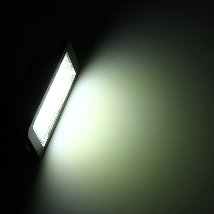 LED license plate light emitting bright white light from black housing and clear lens