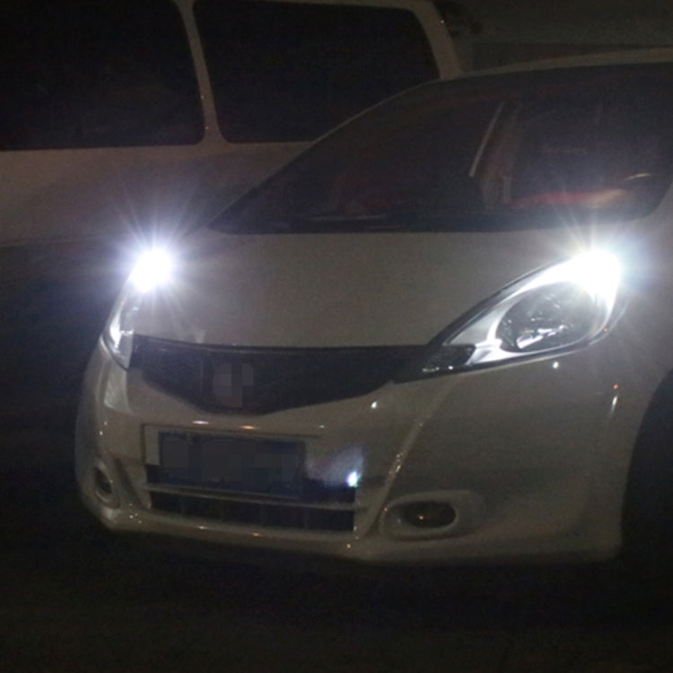 Close view of a car front with two bright white LED light beams at night.