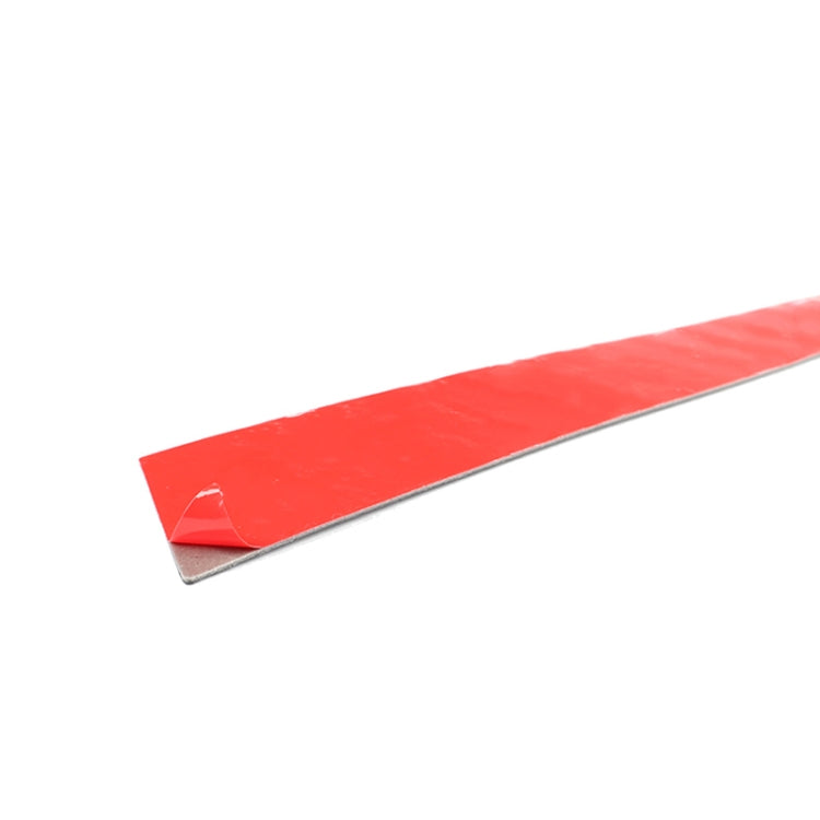 Black carbon-fiber strip decal with red release liner edge