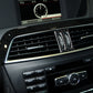 Installed carbon fiber air vent trim with two vertical oval openings and silver accent strips.