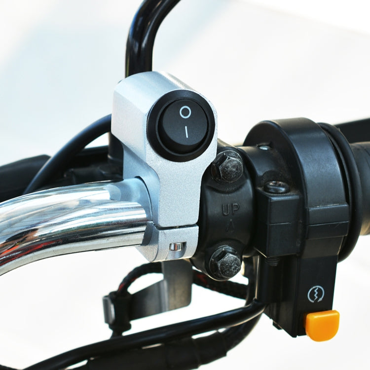 Headlight auxiliary switch mounted on handlebars, silver housing with black 0/I button