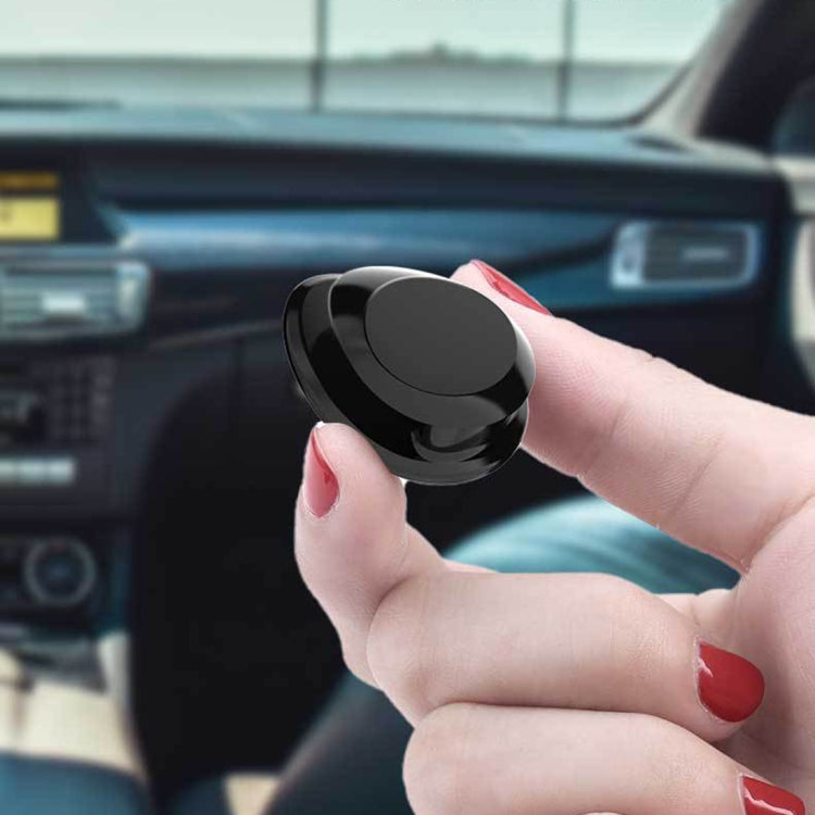 Hand holding a glossy black car mini bag hanger hook for dashboard mounting
