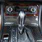 Carbon fiber cigarette lighter panel trim on dashboard, dark woven texture around shifter