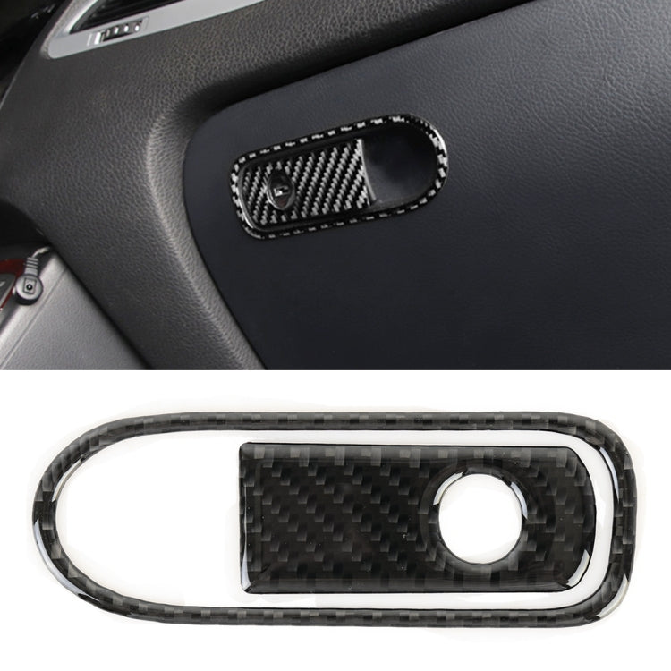 Carbon fiber-pattern armrest switch bezel with oval frame and circular switch opening