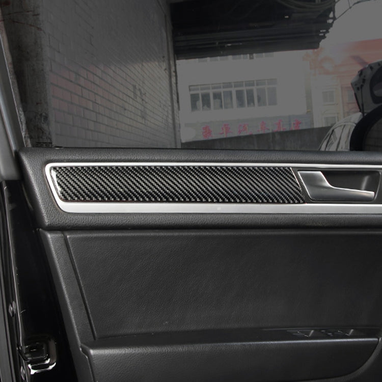 Black carbon fiber door panel trim sticker installed along inner door handle bezel