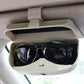 Beige car sunglasses case with card slot, open to hold black eyeglasses