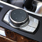 Installed IDRIVE knob cover with arrow icons and silver rim on dashboard control panel