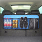 Dark blue car trunk hanging storage bag with mesh window, holding shoes, cans, and bottles
