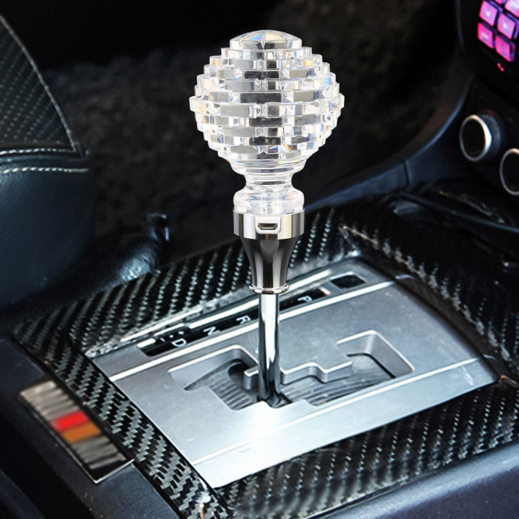 Crystal gear shift knob with faceted clear top, chrome stem and illuminated base in car