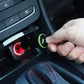 Hand inserting mini car charger into 12V socket; green-accent ring on charger plug
