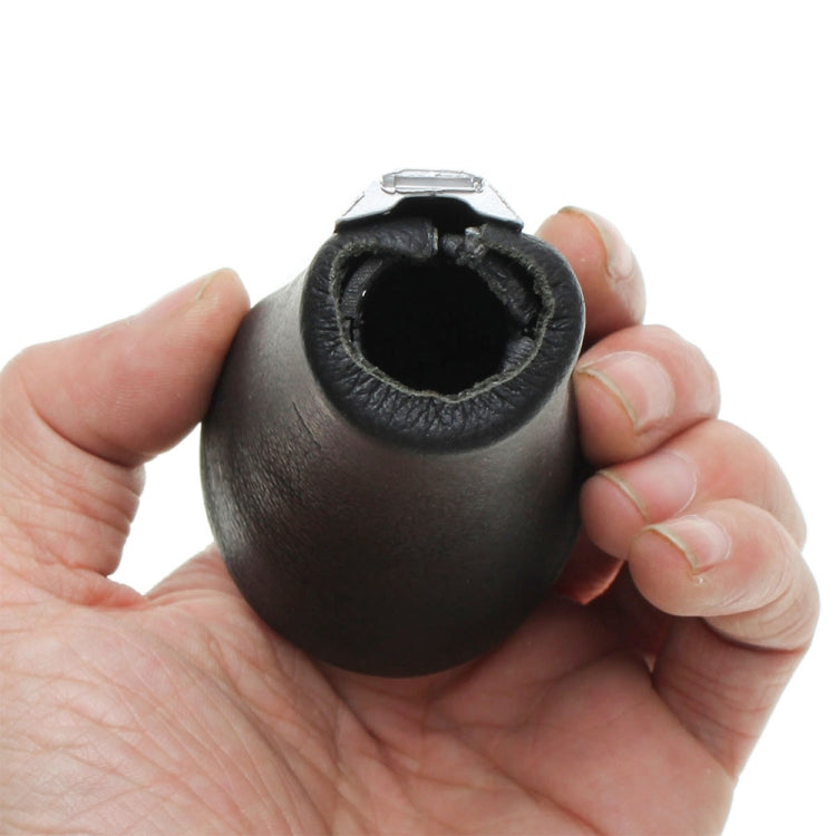 Black leather gear shift knob top view held in hands, showing circular socket