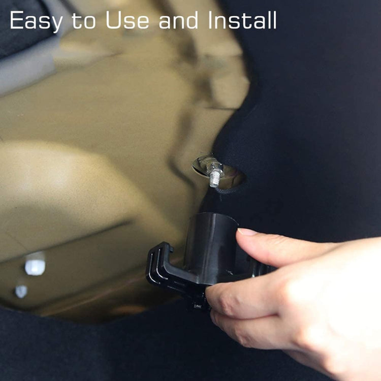 Hand installing a black trunk bag hook under the car cargo area trim