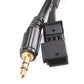 Close-up of 3.5mm gold-tip plug and BMW connector on black audio adapter cable