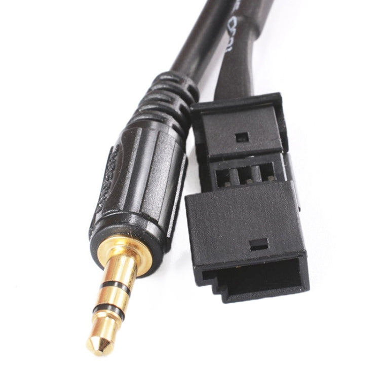Close-up of 3.5mm gold-tip plug and BMW connector on black audio adapter cable