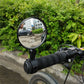 Bicycle rearview mirror with convex lens mounted on handlebar near the grips.