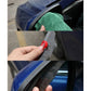 Hand applying black rearview mirror rain blade to car side mirror