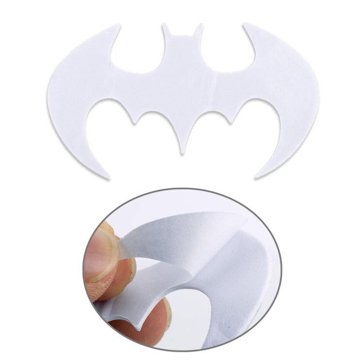 White bat-shaped metal car sticker with peel-off backing shown