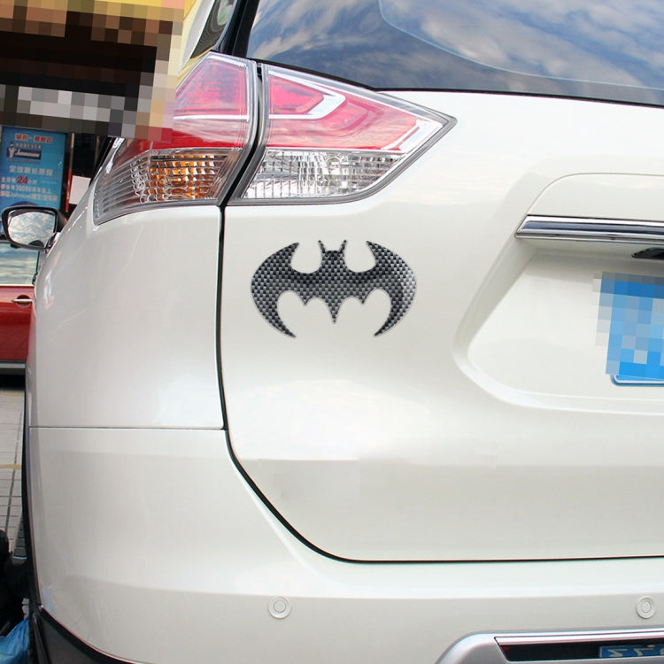 Bat-shaped metal car sticker with dark carbon-fiber bat icon on car body