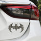 Bat-shaped metal car sticker with lighter, textured carbon-fiber bat icon on car body