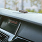 Metal parking number roller card mounted on car dashboard, digit window visible