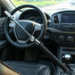 Installed U-shaped steering wheel lock with black arm across steering wheel spokes