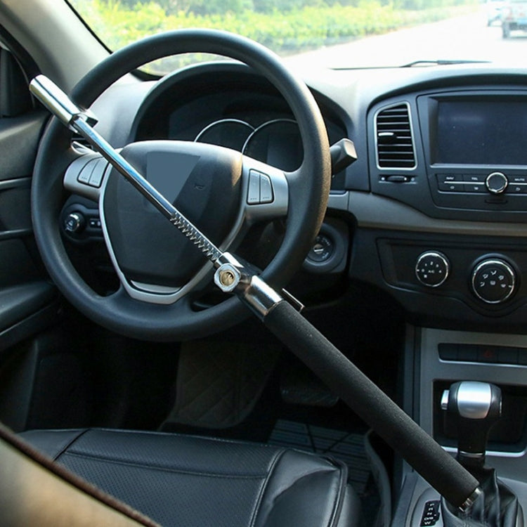 Installed U-shaped steering wheel lock with black arm across steering wheel spokes