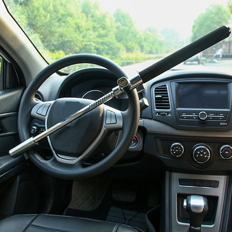 Car steering wheel lock secured across the steering wheel with black telescopic handle