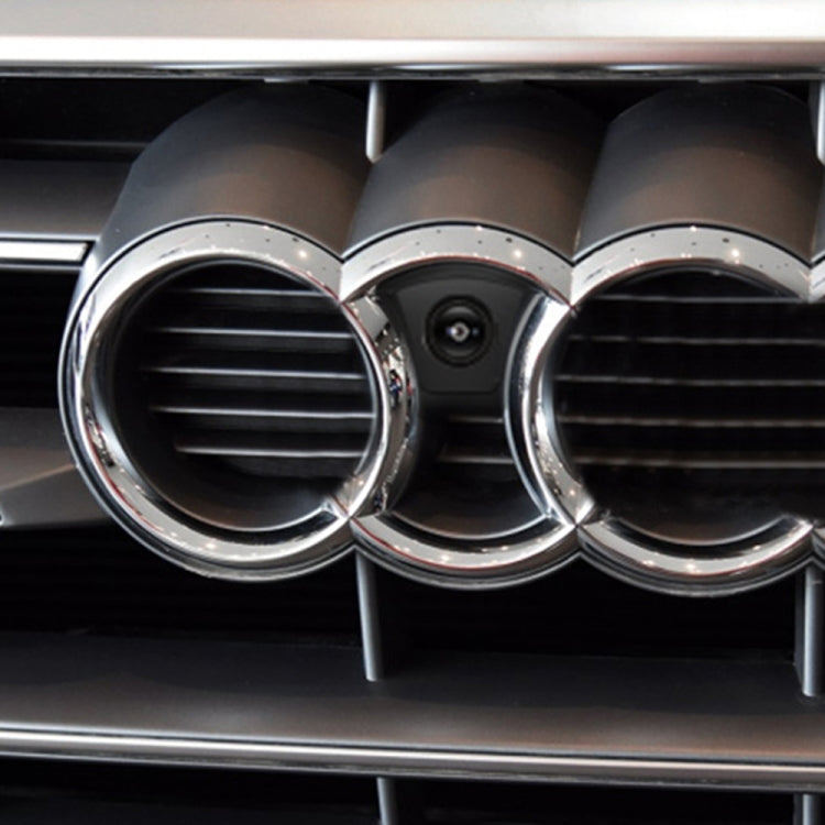 Installed front camera centered in grille opening with chrome surround on car